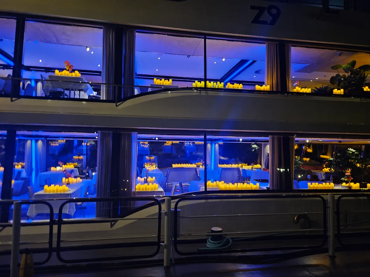 Het verlichte schip van De Zilvermeeuw, met kaarsen zichtbaar door de ramen