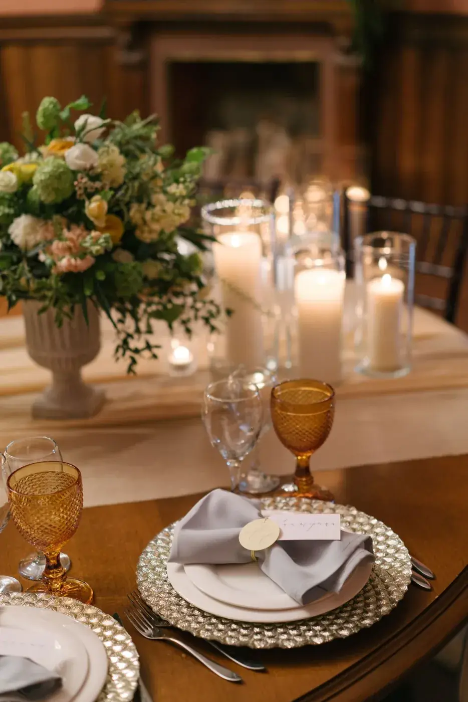 Rustig gedekte dinertafel met kaarsen, bloemen en wijnglazen.