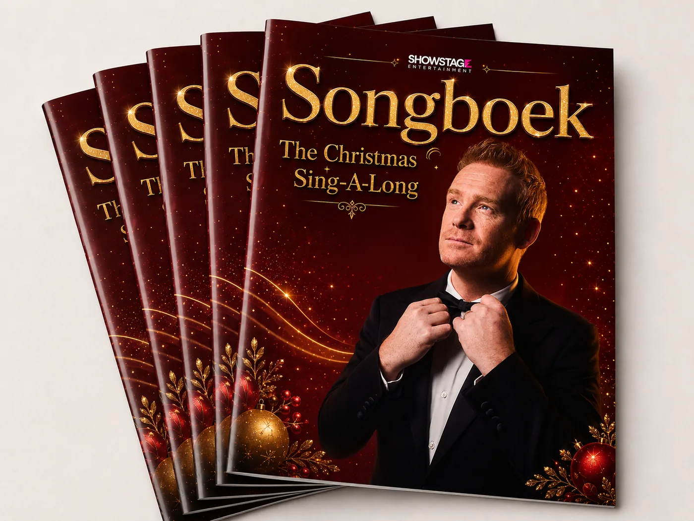 Een stapel songboeken van The Christmas Sing-A-Long met de show-artwork op de voorkant